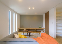 リビングスペースは3本の縦長スリットガラスがポイント。TVボードは部屋に合わせて造作したもの。右手の白い棚は可動式になった魅せる収納。右手奥の扉は物置になっていて、見せたくない季節家電などを収納できる