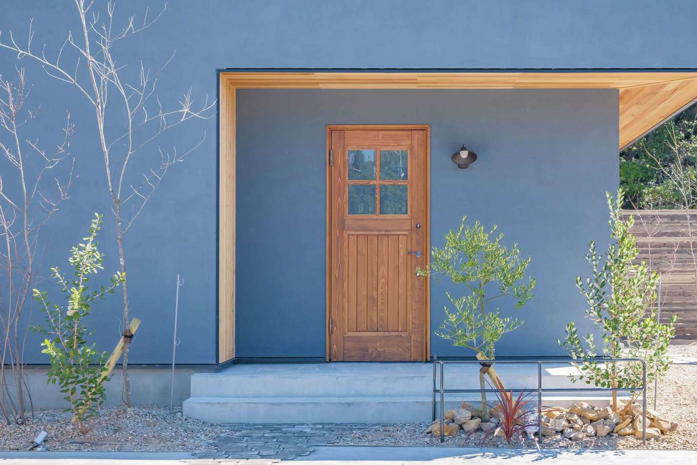 ARRCH アーチ【デザイン住宅、間取り、建築家】道路に面した美容室のエントランス。奥さまのこだわりで、アンティークの風合い漂う木製ドアを採用。外部から室内に直射日光が入りすぎないように開口部などが工夫されている