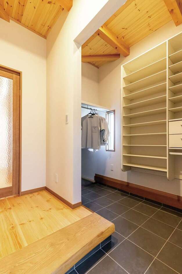 タモの天然木を使用した耳付きの框（かまち）が高級感をもたらす玄関。土間をL字型にして、シューズクロークを確保