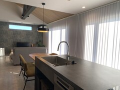 広々としたLDKで、開放的な空間が特徴。モダンなデザインの照明とシンクがける、リラックスできるダイニングスペースを提供している。
