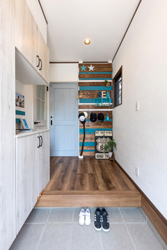玄関も白×木で統一。正面のウォールボードは家族の手作り