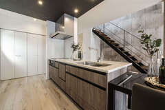 キッチンを起点に回遊できる便利な家事動線。正面に見えるスケルトンのスチール階段は存在感たっぷりで、インテリアの一部にもなっている