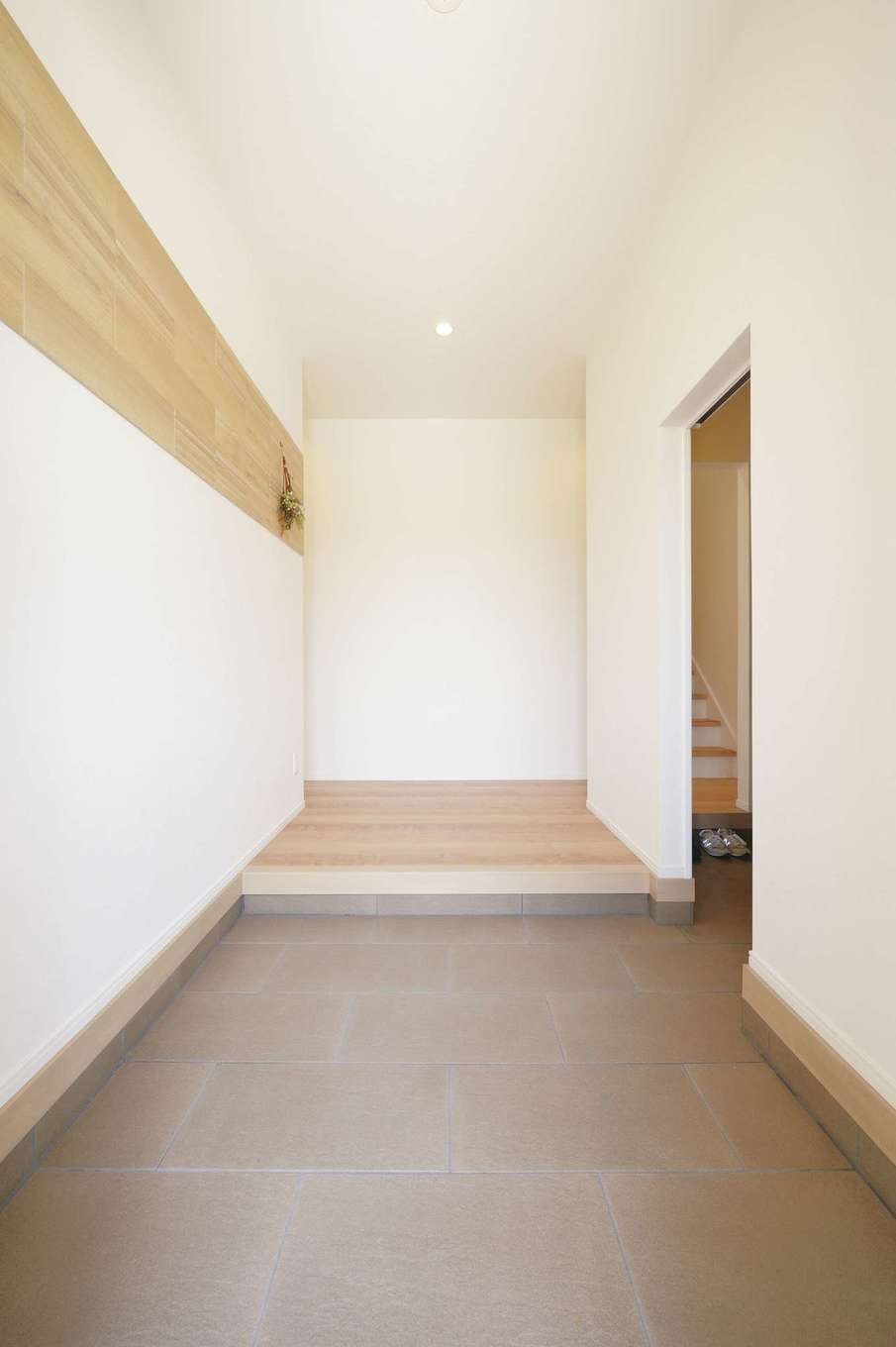 丸昇彦坂建設【デザイン住宅、子育て、間取り】シューズクローク付きの玄関。色を抑えたシンプルな空間にアクセントタイルで個性をさりげなく表現