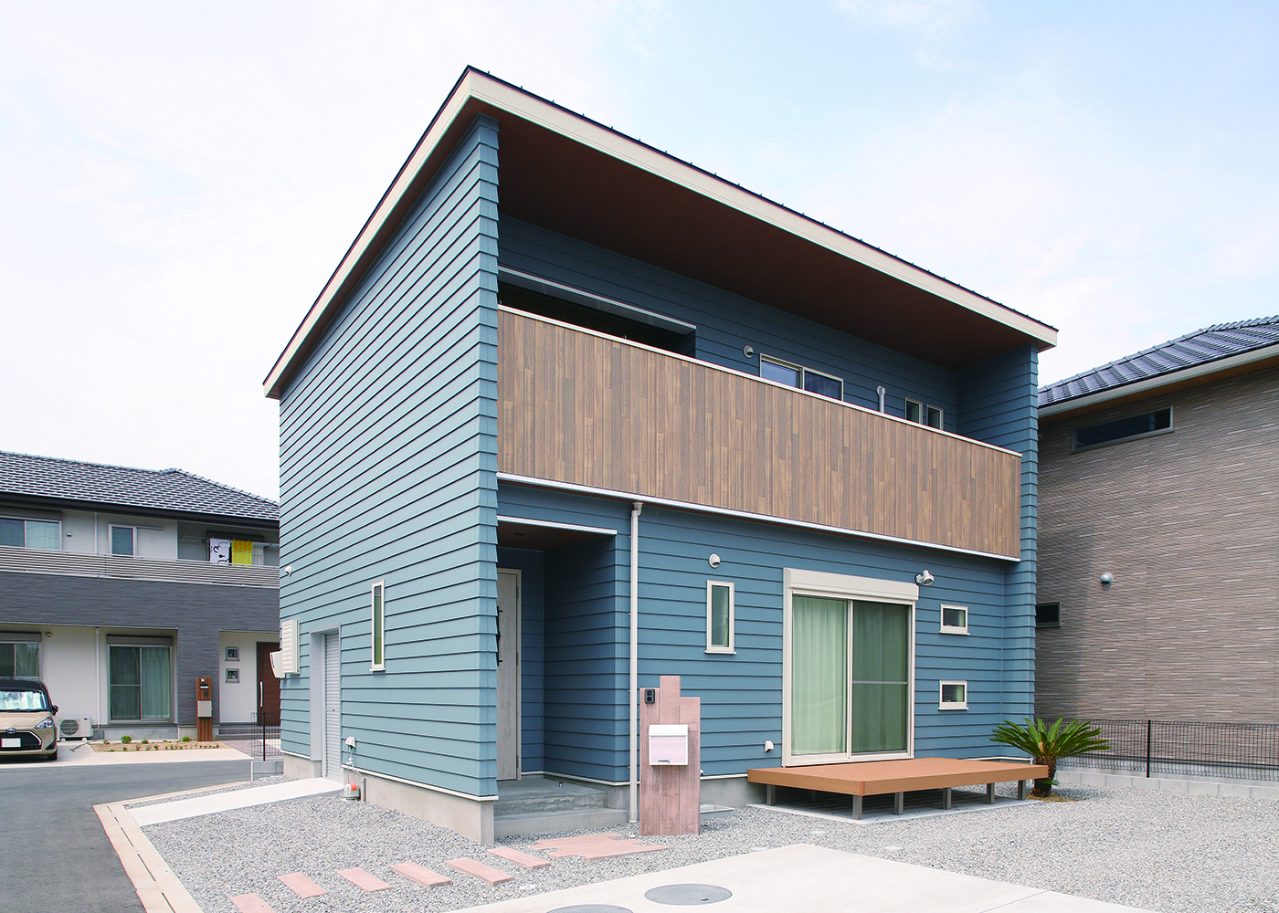 丸昇彦坂建設【デザイン住宅、趣味、間取り】小幅の板を一枚一枚重ねながら張り合わせいくラップ仕上げの外観。ハワイをイメージしたヤシの木がアクセントに