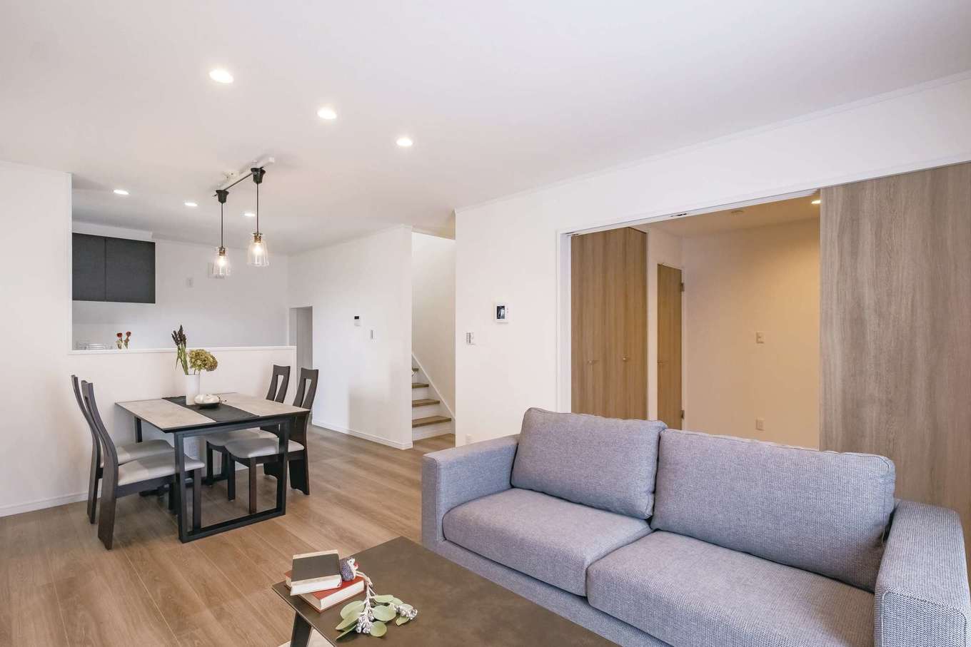 ＩＤＫ 住まいの発見館【1000万円台】LDKには人気のリビング階段を採用。キッチンのママのもとに、朝のおはようから、玄関のただいままで、家族の様子が表情とともに運ばれる。和室はLDKとの統一感をもたせることにより、空間の広がりを演出しつつ、利用頻度を高めている。階段下には可動棚を備えた収納。限られたスペースが有効に活用されている