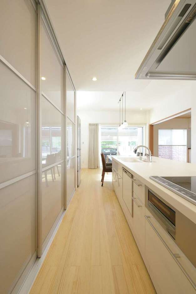 調理家電やゴミ箱の入ったバックヤードを3連の引き戸で隠すことにより、生活感を出さない