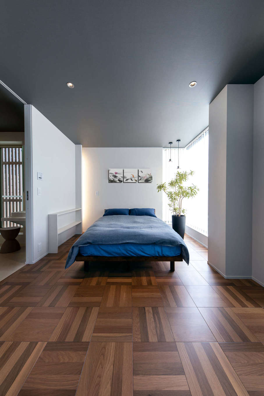 建築システム（狭小住宅専門店）【静岡市駿河区東新田3-2-27・モデルハウス】3階の寝室は和モダンのデザイン。建具は天井まで届くハイタイプにして縦空間の延びを強調、視覚的にすっきりしている。床材はちょっとレトロ感のある寄木のフローリングに
