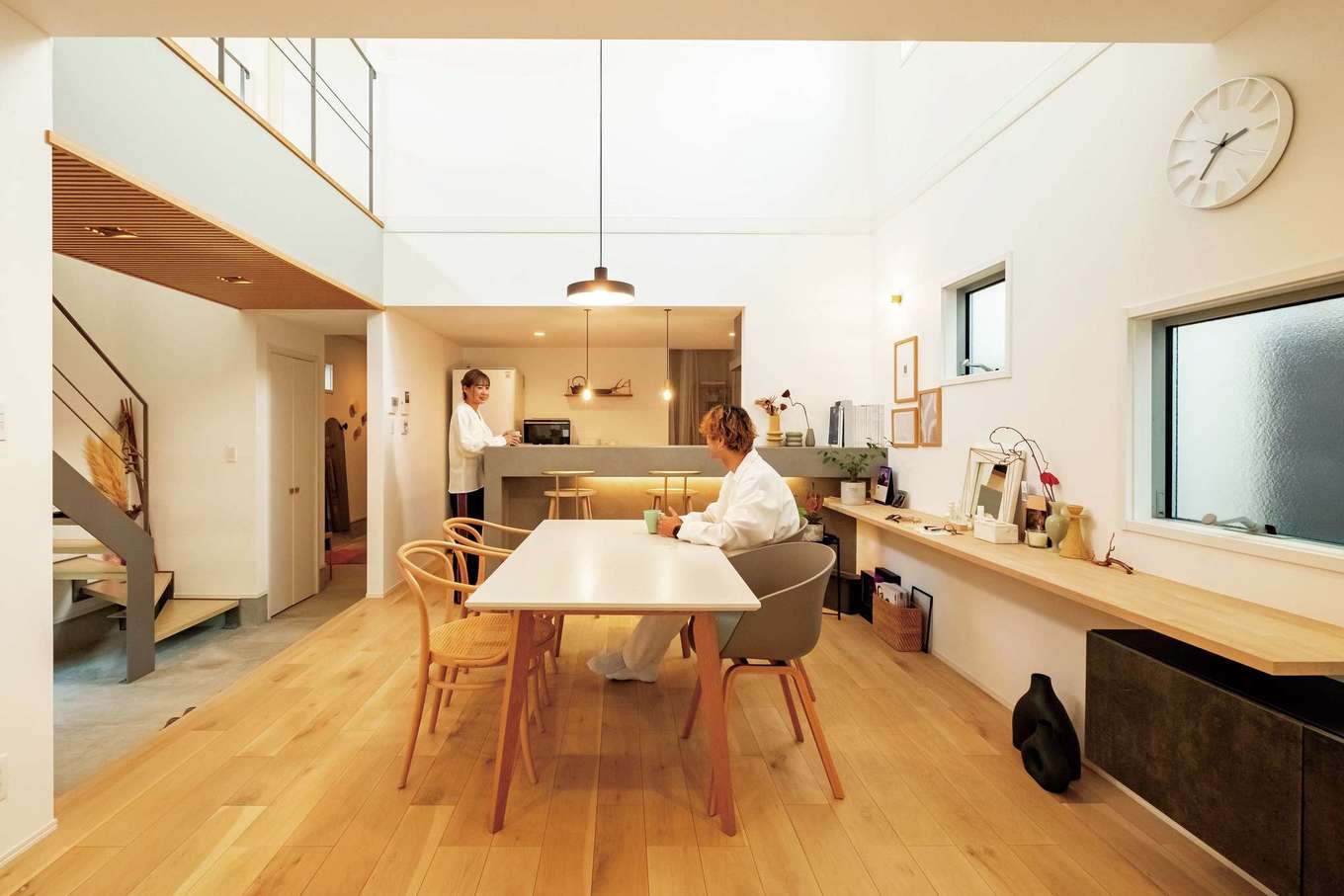 ハートホーム【デザイン住宅、高級住宅、間取り】細長い土地形状を活かした横並びの配置のLDK。土間とLDKは段差をつけてゾーニング。全体を白、グレー、木目と色数を抑えてコーディネートし、品良くまとまっている