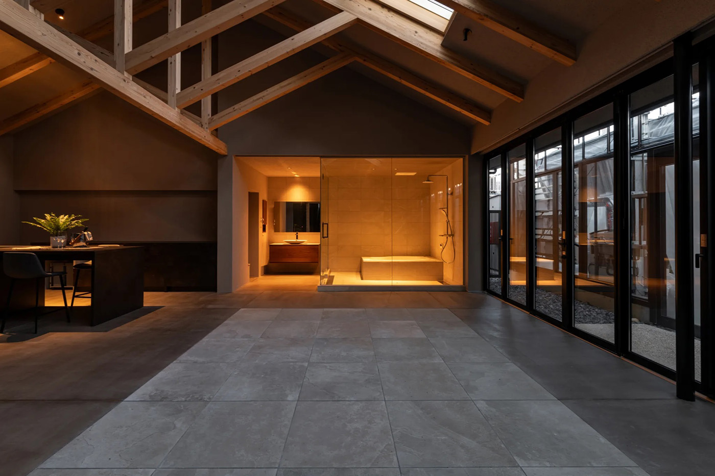 la CASA（ラ・カーサ）【デザイン住宅、平屋、ガレージ】全開口サッシや天窓で内外をなだらかにつなげ、室内の素材は外壁と同じ塗り壁やタイルで統一。これだけの大空間・大開口のある木造建築でも許容応力度計算による耐震等級3を取得し、安心・安全な暮らしを担保している
