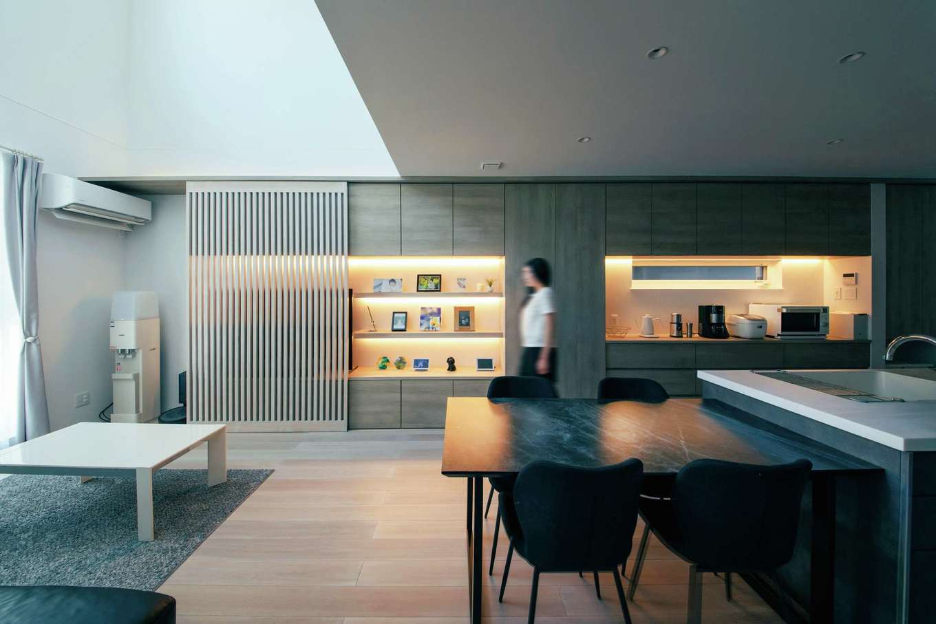 トーリンホーム【デザイン住宅、省エネ、建築家】吹抜けの開放感が気持ちいいLDK。ルーバーでテレビを隠すと、ホームギャラリーが現れる。工務店が可能にした機能性と、建築家による唯一無二のデザインが暮らしを豊かに彩る