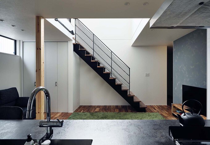 階段は、木製のオープン階段。視線が奥へと抜けるので圧迫感がなく、ブラックアイアンの手すりとの相性もバツグンだ