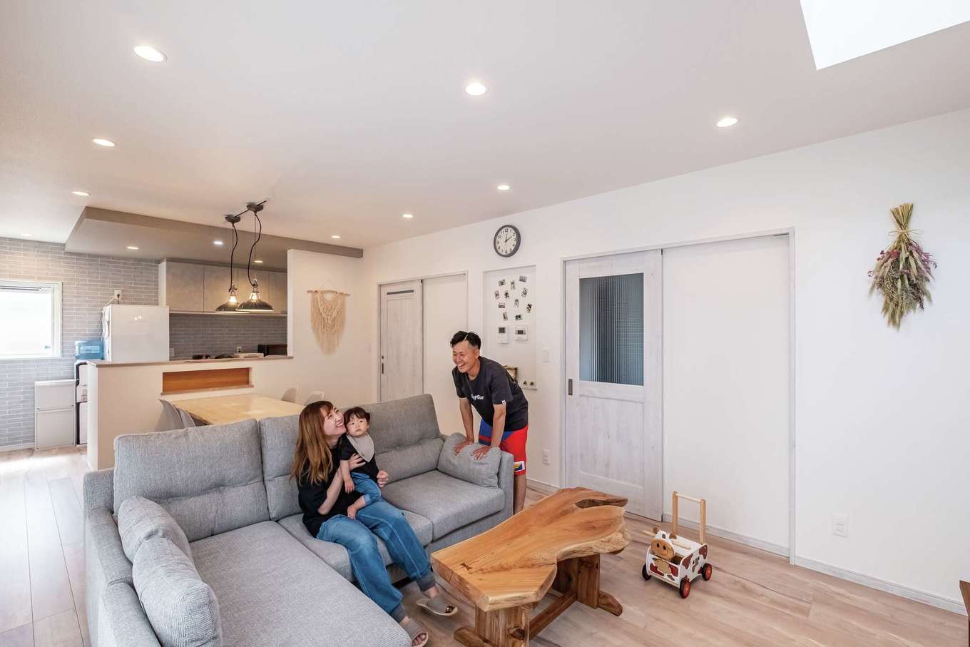 ぽっくハウス【リプルス】【デザイン住宅、狭小住宅、間取り】白を基調とする空間は、庭側に開いた窓と吹き抜けから運ばれる光で満たされ、居心地がいい。もっとも大切にしたのは、家族が近くに感じられること。キッチンには玄関の出入りや階段の上り下りを含め、家族の様子が届く。壁のニッチはマグネットがつくようにしてもらった