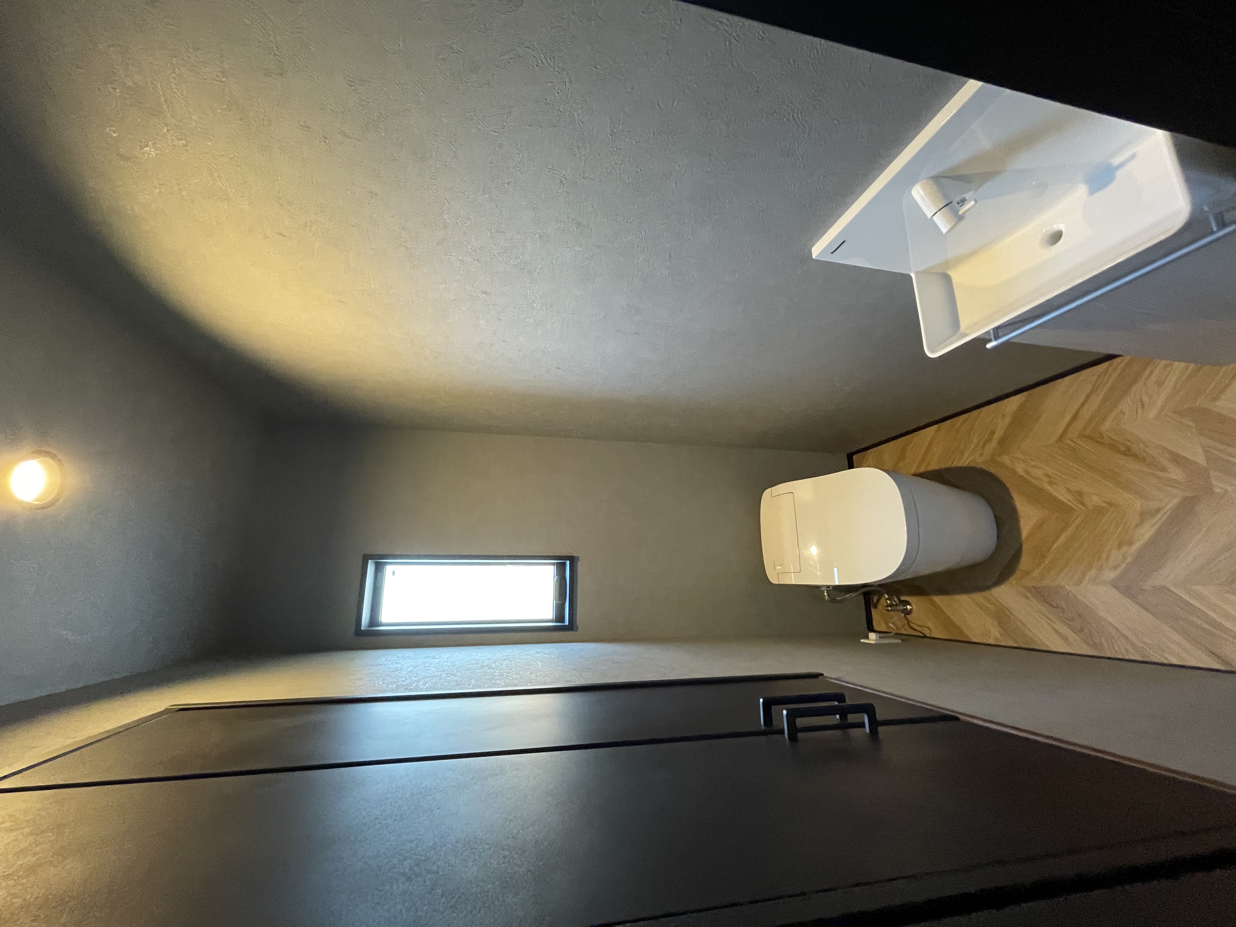 SnugStyle｜シンプルで洗練されたデザインのトイレ空間。コンパクトながらも使い勝手が考慮されており、落ち着いた色調がリラックスできる雰囲気を演出している。