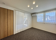 シンプルに徹した6畳の寝室。タイルカーペット敷きで落ち着きのある空間を演出している