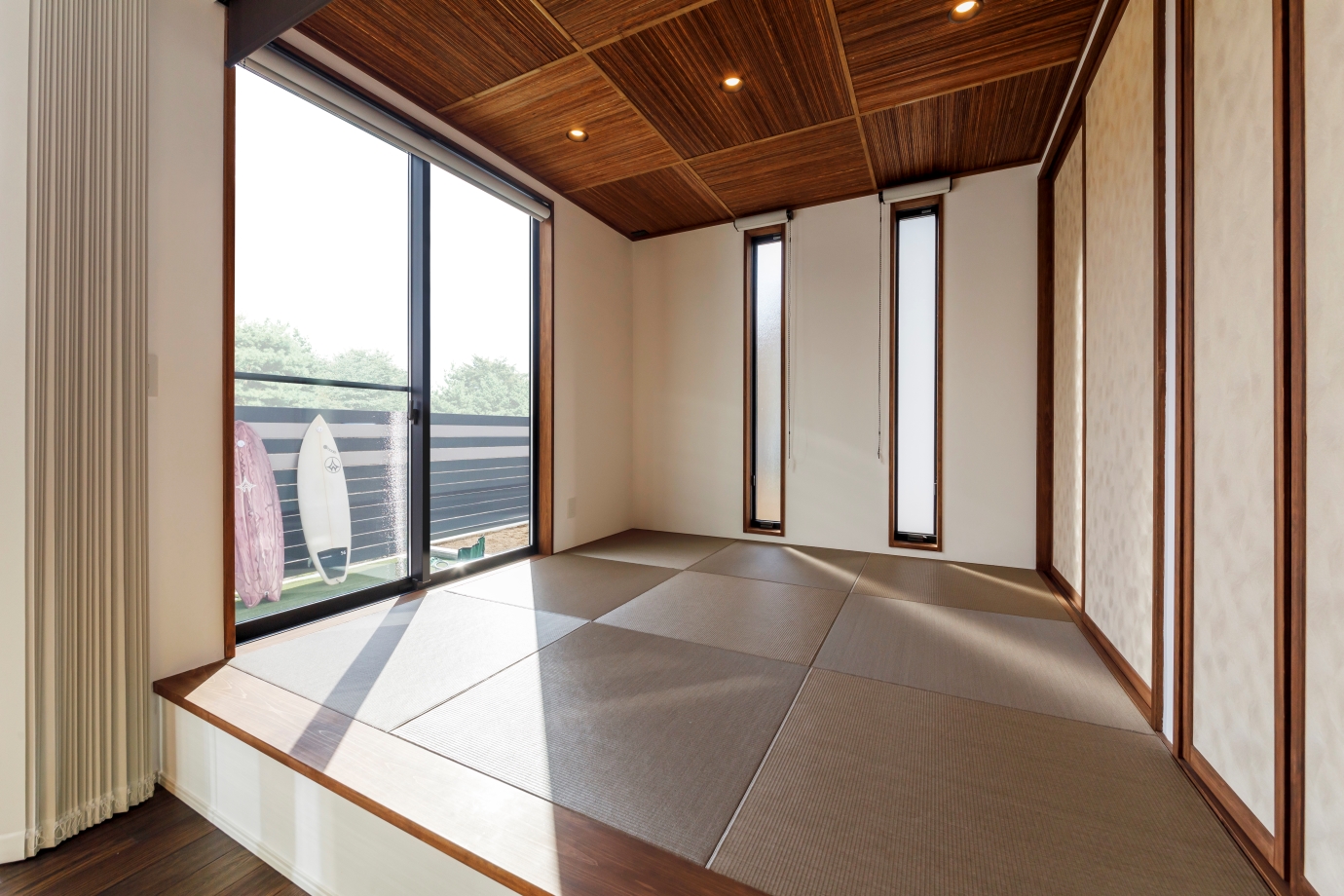 nattoku住宅【デザイン住宅、子育て、間取り】普段はお子さまの遊び場＆お昼寝スペースとして活躍する和室は、ロールスクリーンで区切ることで客間としても機能する。代萩天井で和のエッセンスとくつろぎを加えつつ、スタイリッシュなLDKとの統一感を意識して、モカ系の畳を選んだ