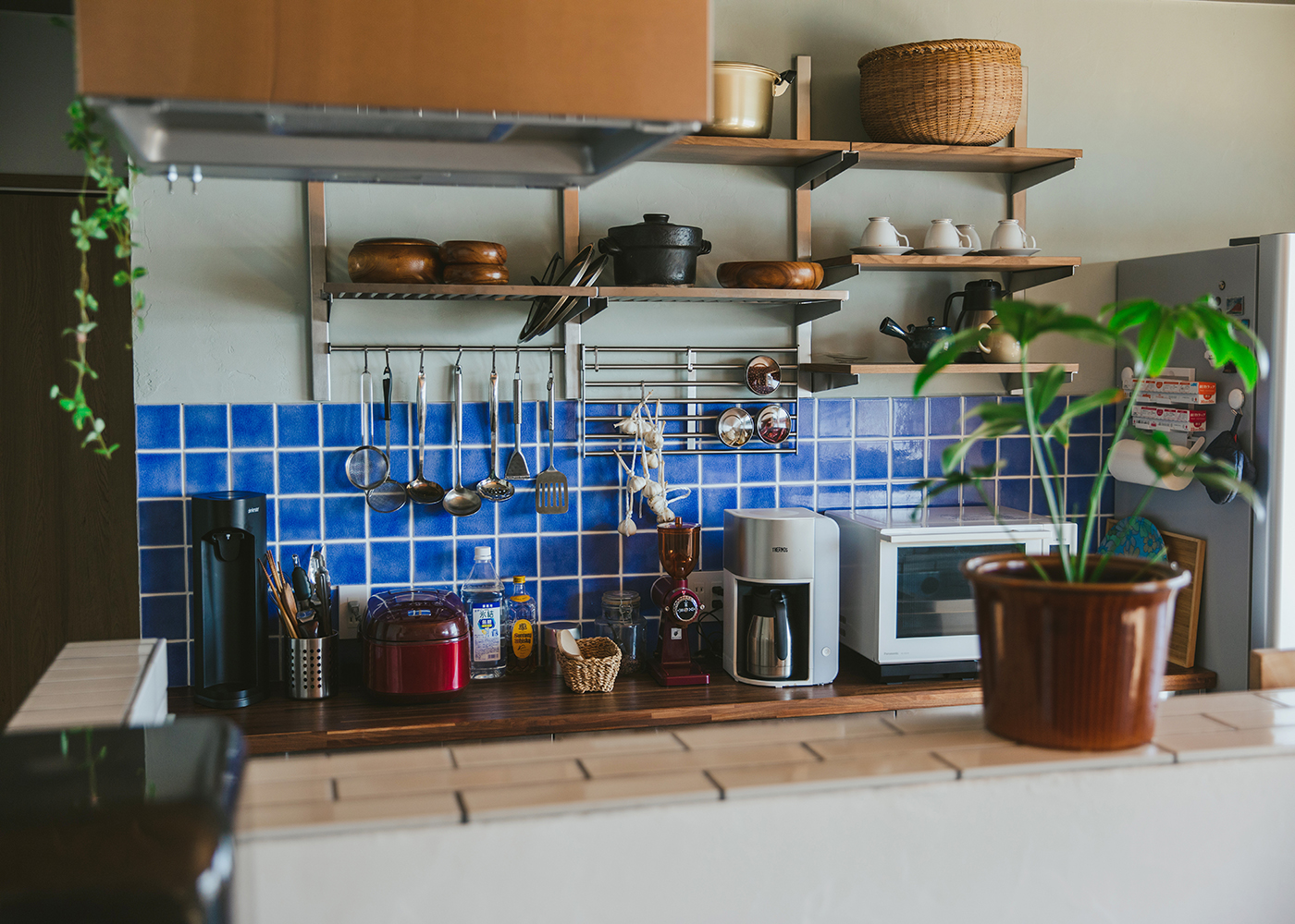 ナイスホーム【デザイン住宅、間取り、平屋】キッチン背面の収納部分には青いタイルを貼った