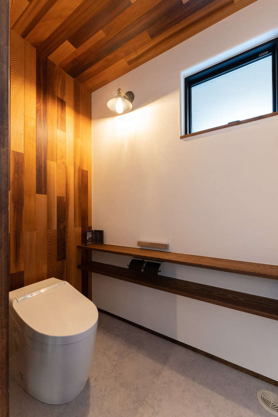 バルハウス【デザイン住宅、自然素材、間取り】カフェのトイレをイメージ。背面と天井に張ったレッドシダーが、ブラケット照明が生み出す情景に美しく映える