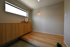 グレージュの壁紙と、オークのフローリングの組合せがオシャレな玄関。
幅広の玄関収納を設け、収納力もバッチリ。