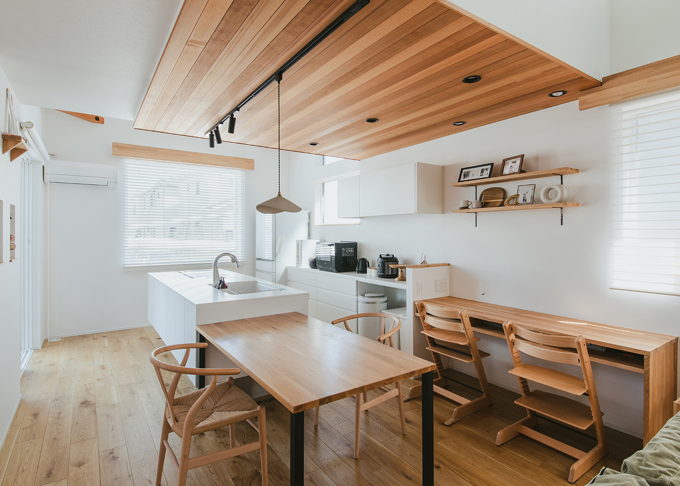 ainoa.life くらはし建築【子育て、収納力、間取り】木の温もりが感じられるダイニング空間。ナチュラルな色合いのテーブルと椅子が配置され、窓からの自然光が心地よく差し込む