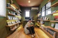 読書が大好きな奥さまの夢を叶えた図書室。吹き抜けに面した「デコマド」がアクセントに。本をただぎっしりと並べるのではなく、造作の棚に好きな本だけを飾り、間接照明で照らす。本をアートとしても楽しめる至福の空間だ。大切な表紙カバーが自然光で日焼けしないように、窓の位置や大きさまでが考慮されている