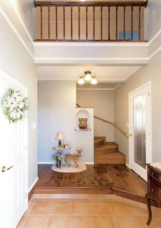 玄関を入ると迎えてくれるのは奥さまお手製のトールペイントのウェルカムボード。右のドアはリビングへ、左は洗面所へと回遊できる