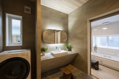 落ち着いた色合いの洗面スペース。洗面台のデザインがシンプルで、隣接するバスルームと一体感あるレイアウトが特徴である。