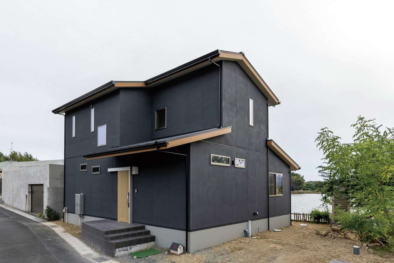 住まいるコーポレーション【収納力、自然素材、間取り】ダークグレーで統一した外観。同社ならではの頑丈な高基礎が、地震や水害などの災害から家族と住まいを守る