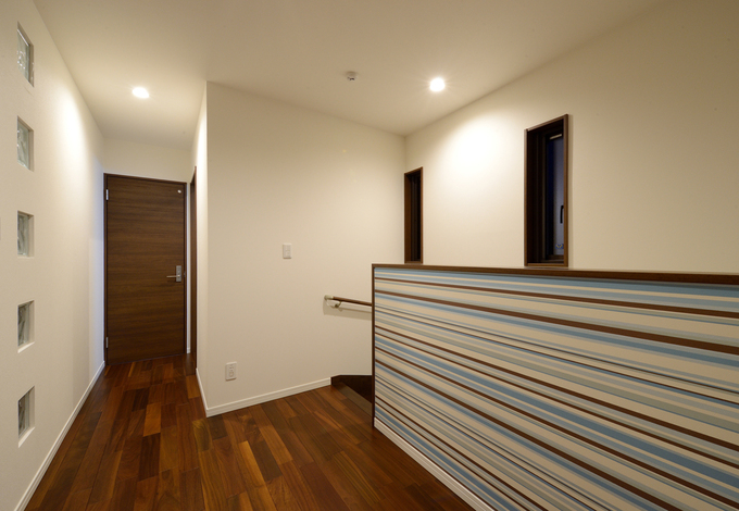 2階のフリースペース。階段のクロスに遊び心を取り入れた。壁にガラスのブロックを採用したことで、LDKも廊下も光を取り入れる