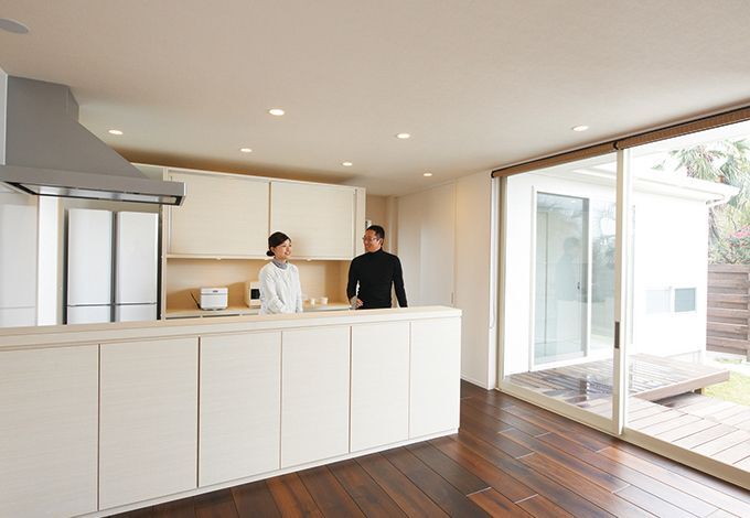 華美な装飾を省き、木の質感を生かしたおしゃれなキッチン。背後に大容量の収納スペースがある