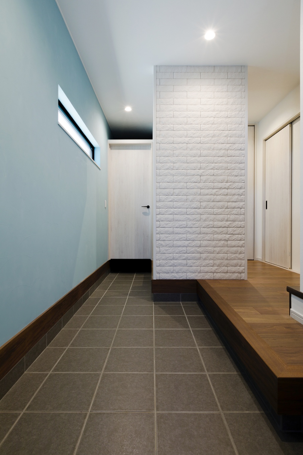 ナイスホーム｜土間を広くとった玄関は、生活感がなく、すっきりとした印象に。側面の壁面には消臭効果のある塗り壁、正面の壁面にはエコカラットをアクセントとして取り入れた