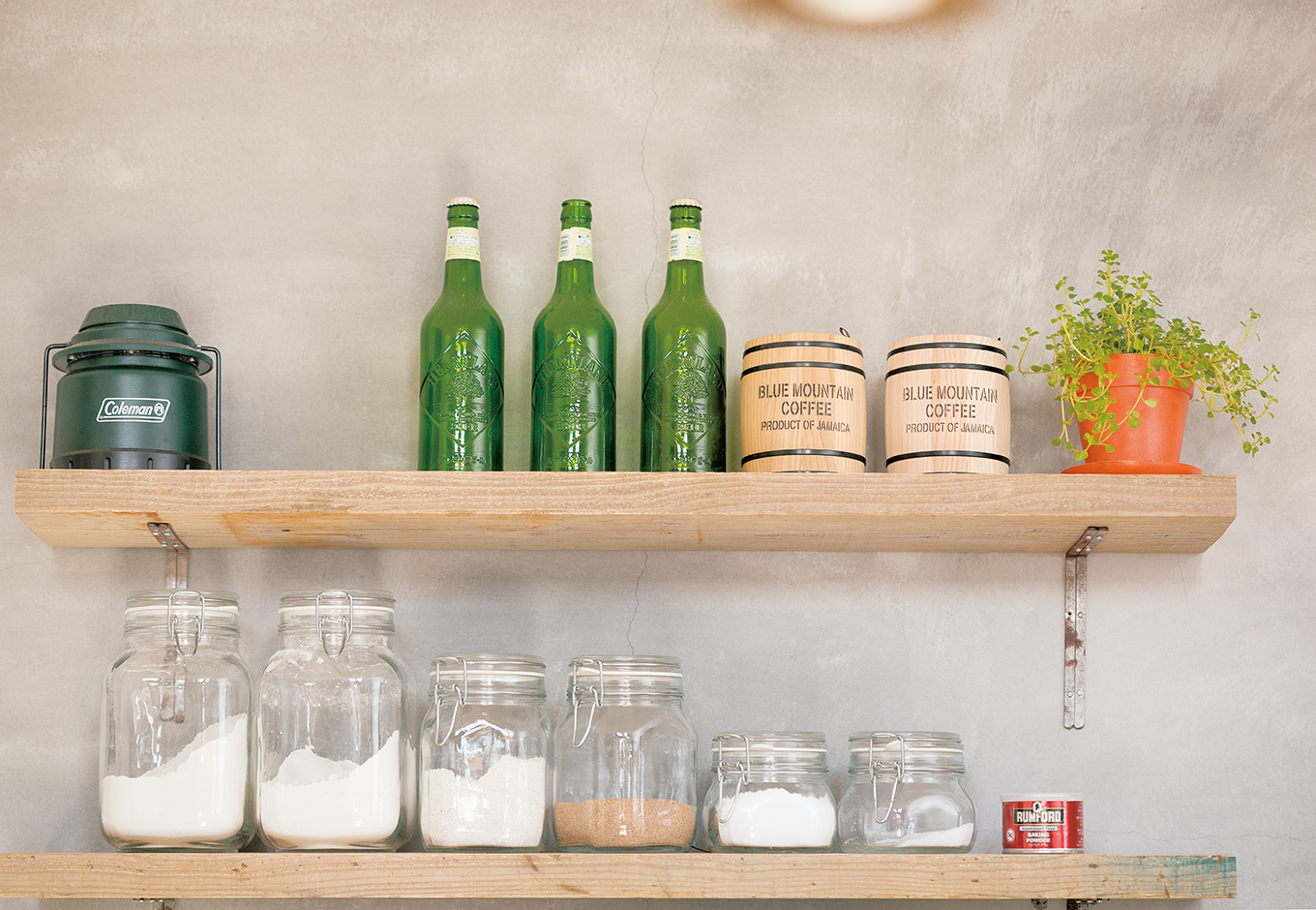 富士ホームズデザイン【デザイン住宅、子育て、インテリア】モルタル壁の質感を活かしたオープン棚。キッチンの壁はすすなどで自然に味わいが出ることを予測して墨を 入れていない。そんな細かい計算もしてくれる