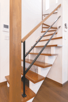 リビングに接する部分はスケルトンにした階段。視覚的にも開放感を感じさせてくれる。手すりはウォルナット色と相性のいいアイアン製に