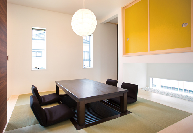 小上がりの畳スペースはダイニング。掘りごたつで、家族団らんの時間をゆったり過ごせる。地窓を切って明るさも確保した