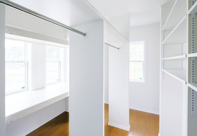 2階の寝室内にあるウォークインクローゼットはなんと6畳。奥さまが趣味のソーイングを楽しむために広い作業台も造作した。両側からポールに衣服をかけられるような配置はアイデア勝ち！