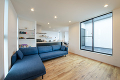 テラスからたっぷりの光が差し込むリビング。無垢の床は程よい凹凸のあるスクラッチ加工で、足裏を心地よく刺激する。L字型のソファも『nattoku住宅』オリジナルで標準仕様