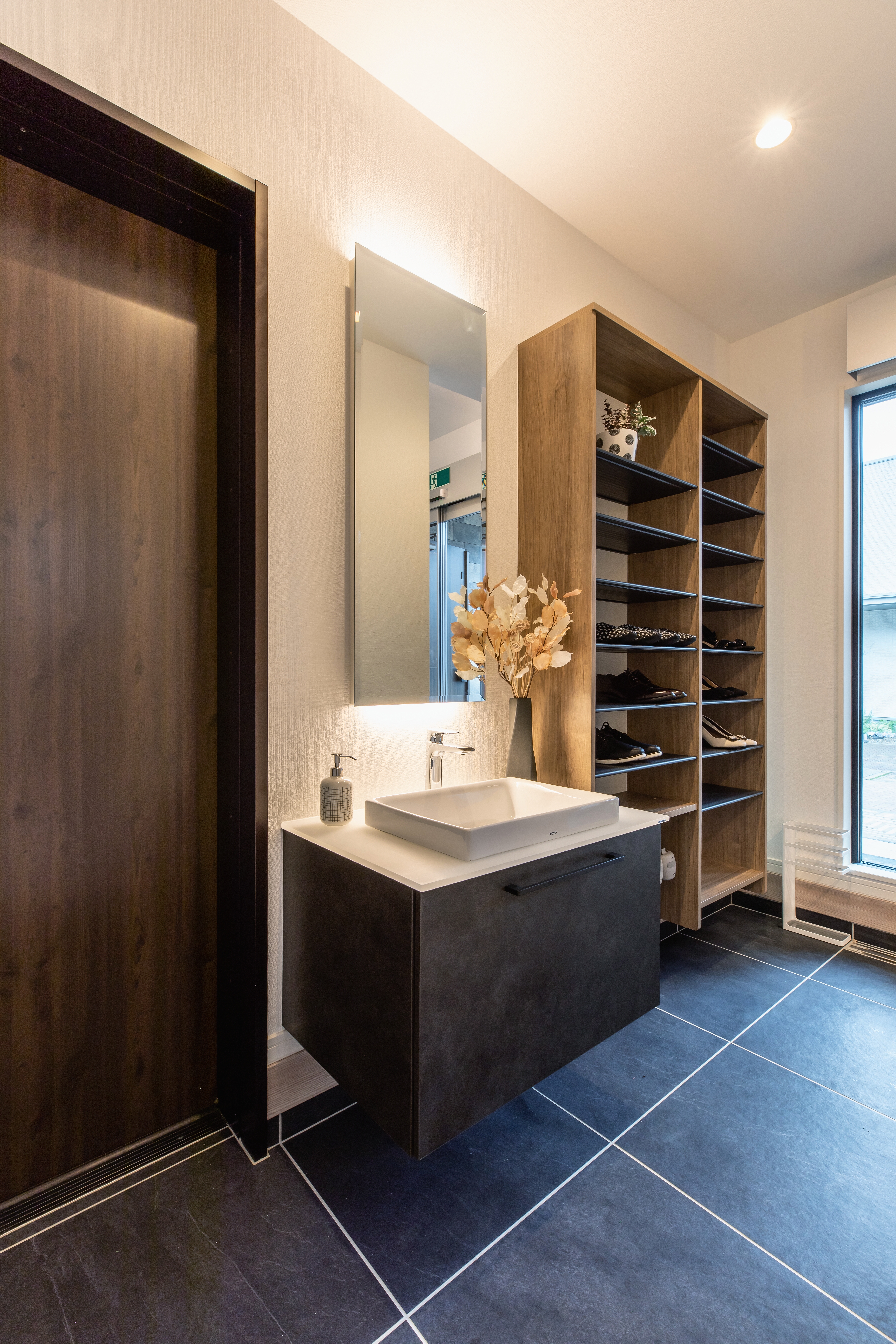 コンチネンタルホーム｜シックなデザインのお帰り手洗い洗面。機能性に優れモダンな雰囲気を演出するスタイリッシュな収納棚も並ぶ。