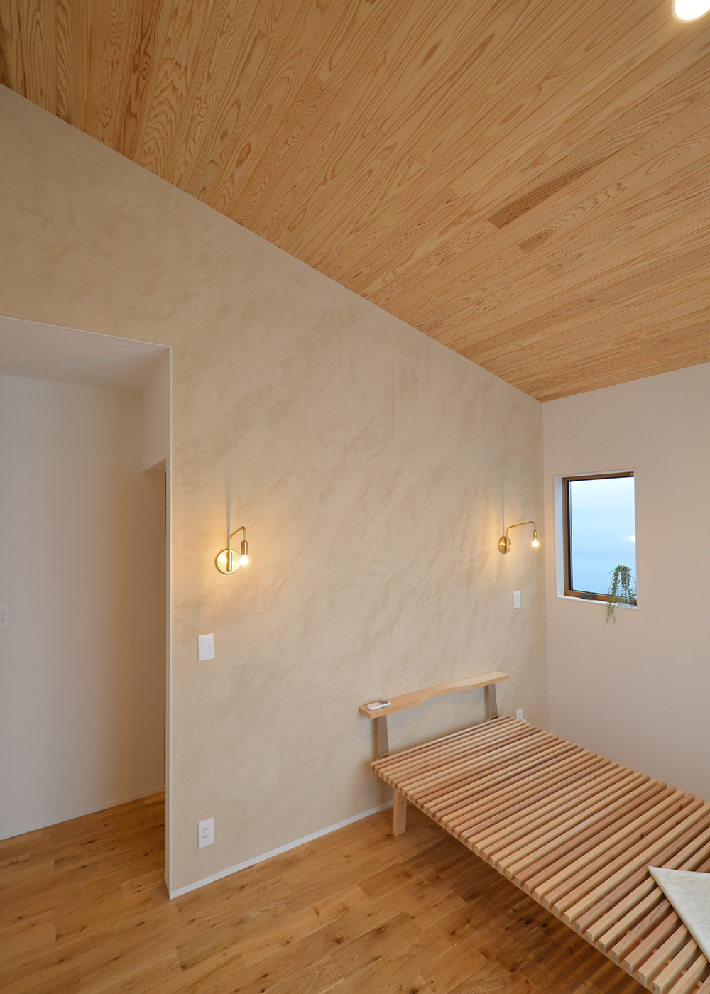 アトリエサクラ【静岡市葵区・モデルハウス】寝室は勾配天井にして空間に広がりをもたらす。天井に張った杉の無垢材には、安眠・誘眠効果のある成分が含まれているので、朝までぐっすり眠れ、健康的な生活をサポートする