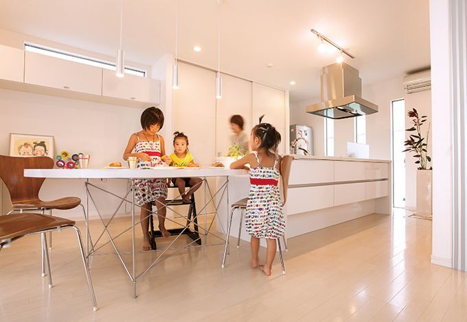 アイランドキッチンと変形テーブルを一列に配置し、調理や片付けがラク