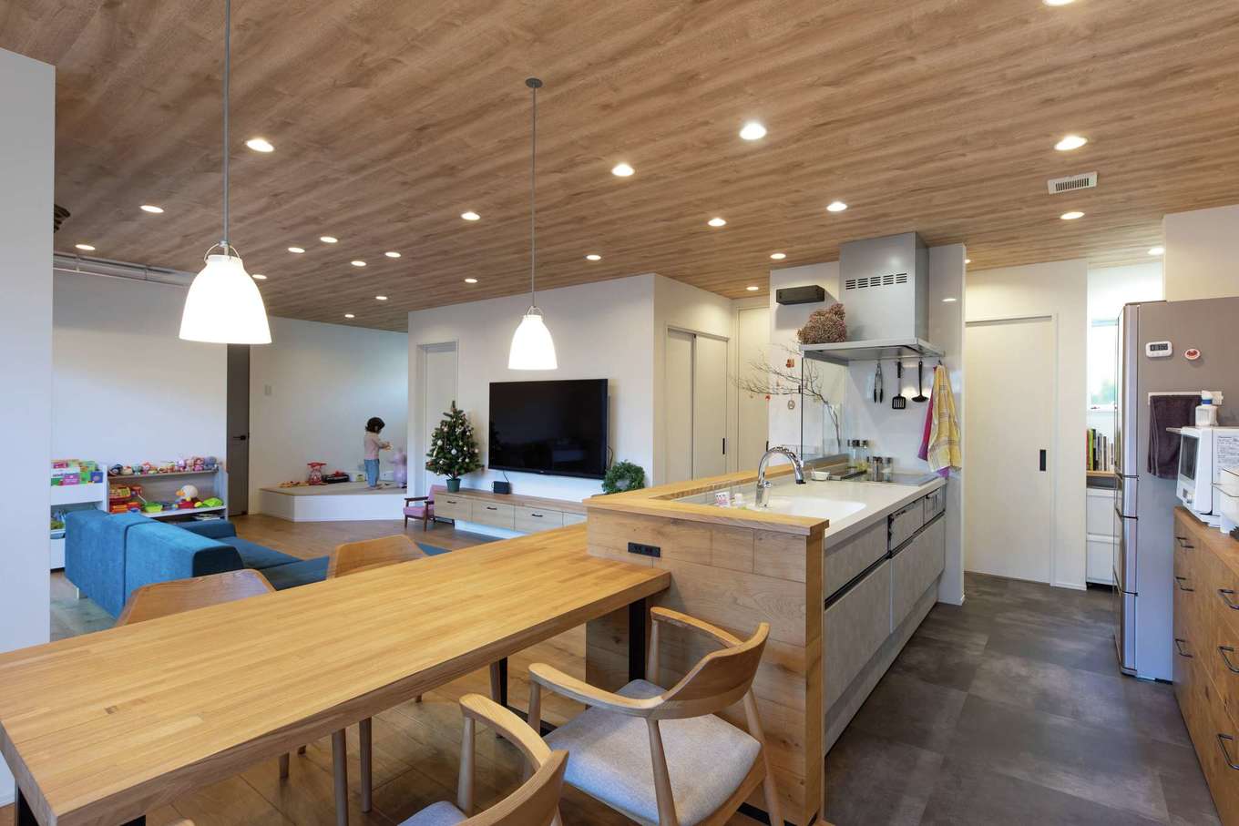 KUREKEN HAUS（榑林建設）【デザイン住宅、省エネ、間取り】キッチンに立てば玄関まで見通せ、安心して子育てができる。テレビ背後には通り抜け可能なファミリークローゼットを配置。キッチン奥のパントリー、カウンターとともに、スムーズな動線が家事の負担を軽減する
