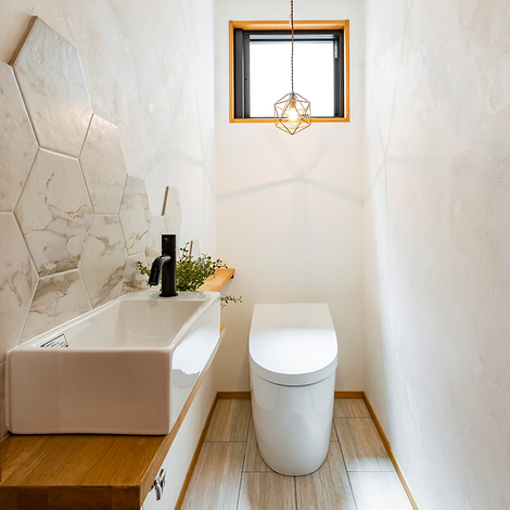 トイレの壁にはヘキサゴンタイルを飾り、洗面の水はね汚れを防止。