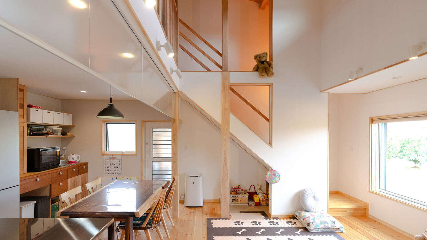瀧口建設【和風、自然素材、平屋】階段を照らす照明が、美しい陰影をもたらす。階段下をうまく活用し、子どもの遊び場に。ダイニング奥にある造作収納は、ご主人の力作だ