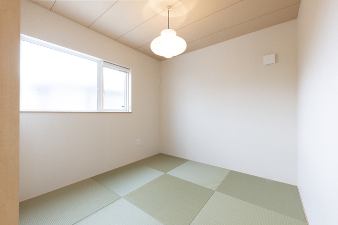 シンプルで落ち着いた雰囲気の和室。畳の緑がアクセントとなり、穏やかな空間を演出している。窓から自然光が差し込み心地よい和室である。