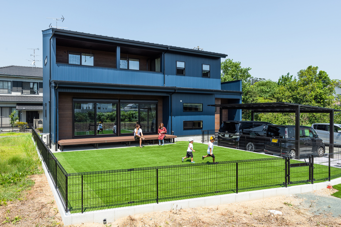遠くの橋からでも外観が見えるよう、紺色のガルバリウムを採用しました。深い軒が夏の直射日光を遮り、冬は室内の奥まで光を届けます。子どもたちは奥行き9メートルの広い庭、その向こうの清流で遊びながら、たくましく育ちます。