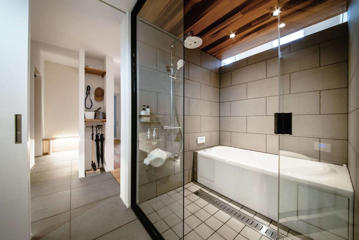 ainoa.life くらはし建築【デザイン住宅、間取り、インテリア】玄関は室内とフラットに繋がり、バスルームに直接行けるようになっている。ガラス張りのバスルームは開放感たっぷりで、贅沢かつスタイリッシュな空間