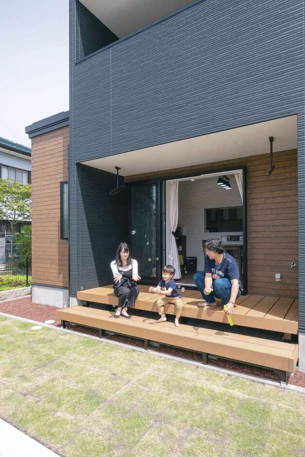 リビングの全開口サッシを開けると、大きなウッドデッキと庭へ。休日はBBQやプール遊びを楽しむ