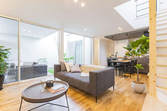 リビングには天井いっぱいまで開口部を設けてあり、中庭の全景が見渡せる。中庭との一体感を存分に味わえるので、家の中にいながらにして開放的な気分でくつろげる