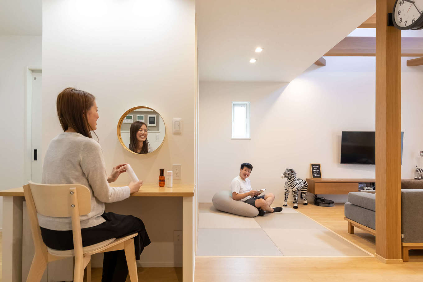ユートピア建設【収納力、省エネ、インテリア】テレビを見ながら化粧ができるメイクコーナー兼アイロンがけカウンターをリビングの一角に造作。丸い鏡がおしゃれ