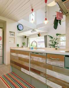 既製のシステムキッチンにアンティーク加工した木板を張ってリメイク。コストを抑えておしゃれにできた