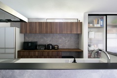 グレーのアクセントクロスを採用したキッチン。
カップボードも床材と合わせた色にすることで統一感が生まれる。

