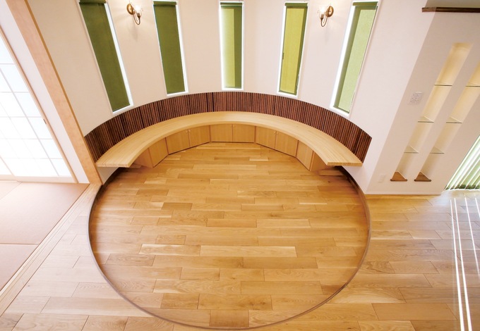 LDKに設けた円形のリビングスペースの壁際には、収納としても活躍するベンチを造作。直線と曲線の巧みな組み合わせで飽きのこないデザインの空間となった